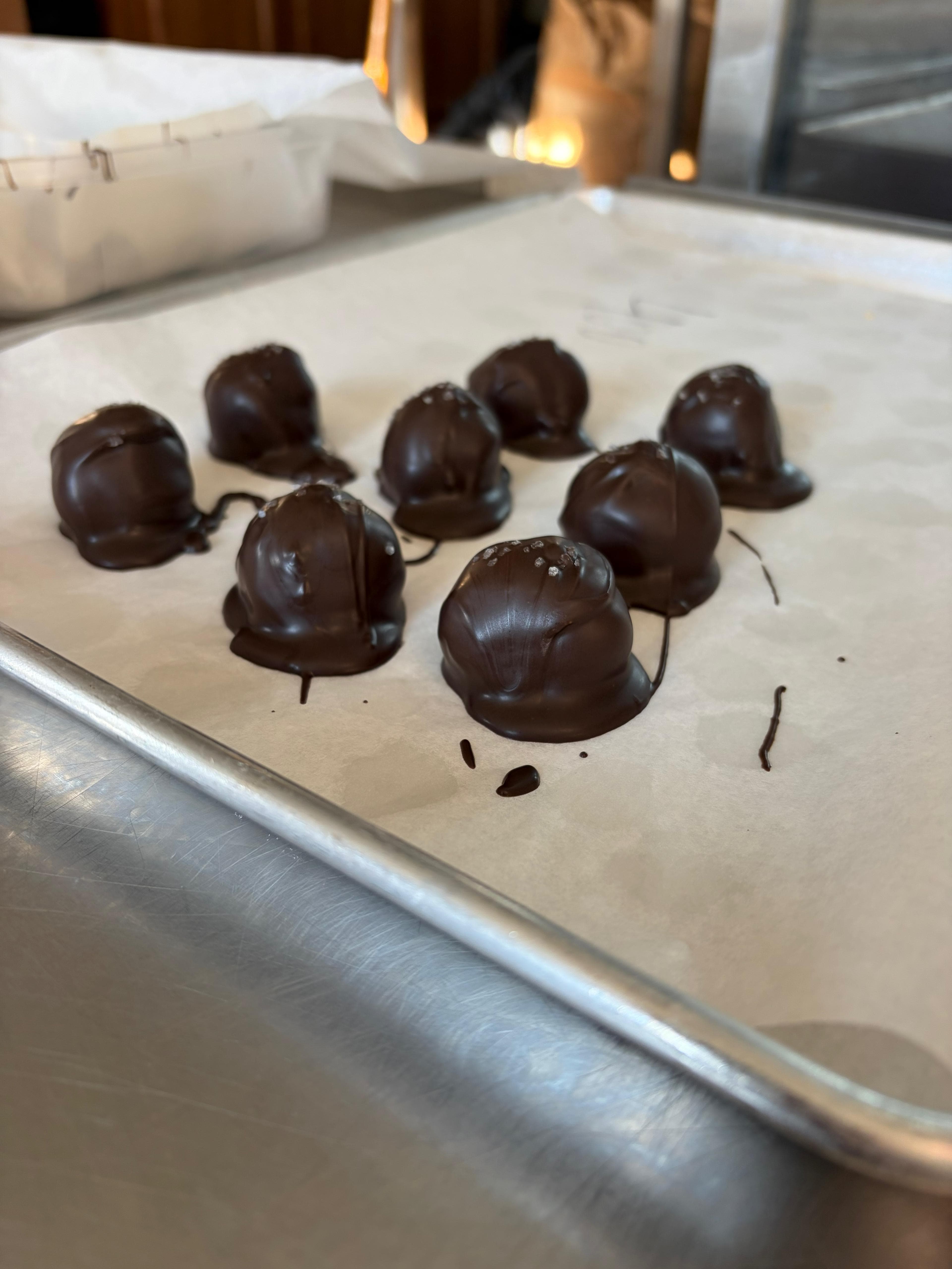 Hand-dipped RSO peanut butter balls setting on a tray in the Aether kitchen